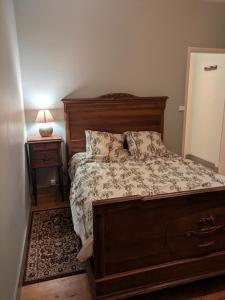 a bedroom with a bed and a table with a lamp at Villa centre ville SOULAC sur Mer in Soulac-sur-Mer