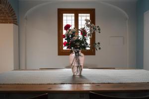 a vase with flowers sitting on a table in a room at Casa Cantia at Villa Mascarello Noventa in Breganze