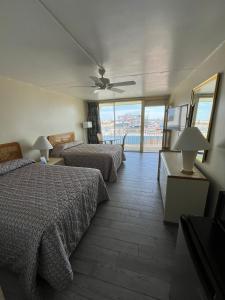 a bedroom with two beds and a ceiling fan at Landmark Motel in Wildwood