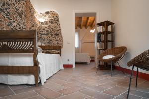 a bedroom with a bed and a stone wall at Casa Cantia at Villa Mascarello Noventa in Breganze