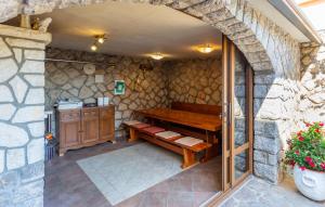 een kamer met een houten bank in een stenen muur bij 1 Bedroom Nice Apartment In Bogovici in Malinska