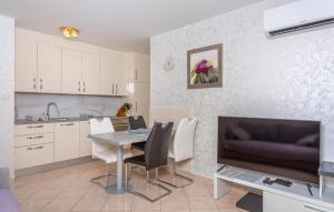 een keuken en eetkamer met een tafel en een tv bij 1 Bedroom Nice Apartment In Bogovici in Malinska