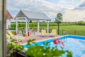 a swimming pool with chairs and a gazebo at Green Oasis Estate with Private Pool and Backyard near Zagreb in Velika Gorica