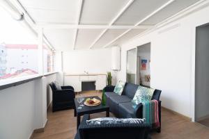 uma sala de estar com um sofá e uma mesa em Gran Atico con terraza em Vigo