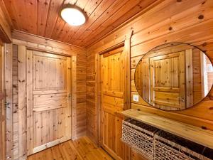 un bagno in stile baita con uno specchio rotondo e pareti in legno di Chalet Ardoise - Nature Paradise - Swiss Alps a Ovronnaz Altre 32 foto