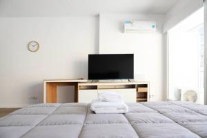 a white bedroom with a bed and a tv at Belgrano amplio luminoso, cochera, WiFi, cerca River y Subte, 308 in Buenos Aires