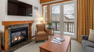 a living room with a fireplace and a tv at 1214 The Lodge At Spruce Peak Ski in Ski Out Studio Spruce Peak By Stowe Mountain Rentals in Stowe