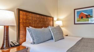 a bedroom with a bed with a pillow and a lamp at 1214 The Lodge At Spruce Peak Ski in Ski Out Studio Spruce Peak By Stowe Mountain Rentals in Stowe +18 photos
