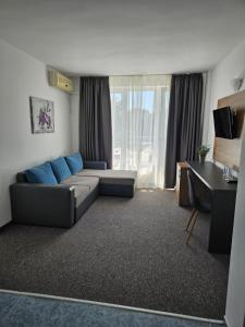a living room with a couch and a desk at Hotel Lotos in Kiten