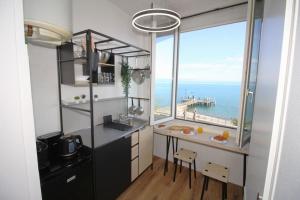 a kitchen with a table and a large window at Studio Bellerive in Publier