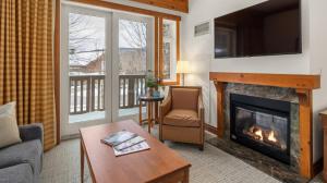 a living room with a fireplace and a tv at 1216 The Lodge At Spruce Peak Ski in Ski Out Studio Spruce Peak Village Views 2nd floor By Stowe Mountain Rentals in Stowe