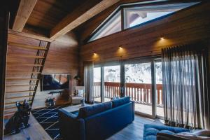 un soggiorno con una grande finestra in una cabina di La Cresta Chalet a Breuil-Cervinia