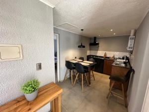 a kitchen and living room with a table and chairs at Cabañas Vientos del Mar in Pichilemu