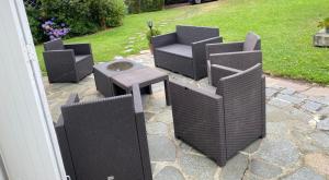 three wicker chairs and a table on a patio at Villa Les Tourelles in Flers