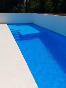 una piscina blu con parete bianca di villa paradise caribbean piscina privata 8 letti a Sosúa