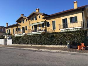 a large yellow building with a fence next to a street at Miniappartamento completo in Stra