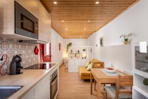 a kitchen and living room with a table and a couch at Casa do Beco in Odeceixe