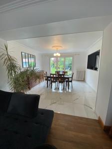 a living room with a table and a dining room at Villa Les Tourelles in Flers