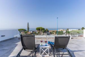 a patio with two chairs and a table with two glasses of wine at Casa Mazagón con vistas al mar in Mazagón +93 photos
