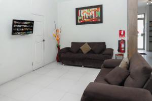 a living room with a couch and a chair at Maximus Inn in Sechura