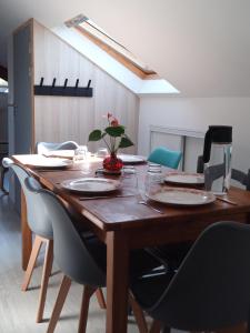 a wooden table with chairs and a plant on it at très grand appartement de 90 m2 avec trois ventilateurs, jusqu'à 6 personnes in Thyez