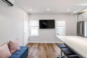 a living room with a blue couch and a tv at 3BR2Bth Parking Cambridge Boston W&D Subway AC in Somerville