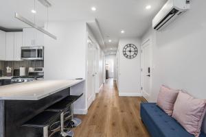 a kitchen with a blue couch and a clock on the wall at 3BR2Bth Parking Cambridge Boston W&D Subway AC in Somerville