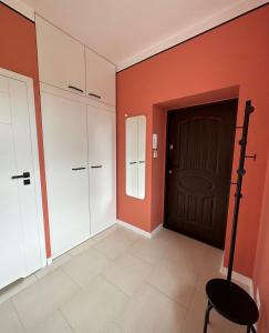 a room with orange walls and a black door at Apartament TAMAJA in Bielsko-Biala