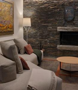 a living room with a couch and a fireplace at Hotel Saurat in Espot