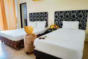 a hotel room with two beds and a chair at KALINA HOTEL in Girardot +27 photos