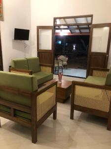 a living room with three chairs and a television at Mango Hacienda in Kuchchaveli