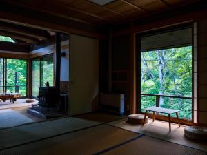 a living room with large windows and a table at Woody Island in Hakuba