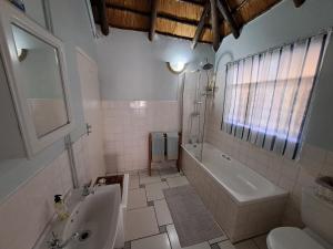 a bathroom with a tub and a toilet and a sink at Valley View in Waterfall +3 photos