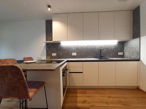 a kitchen with white cabinets and a counter top at Nido City Studio in Brixen