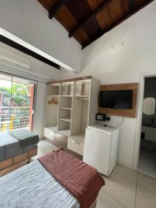 a bedroom with a bed and a tv and a tvictericter at Break House Beach in Florianópolis