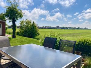 a table and chairs with a view of a field at Huus ACHTERN DIEK by fewo-plan HORS115 an der Nordsee bei Horumersiel-Schillig in Wangerland
