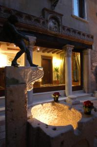 Eine Statue eines Mannes, der auf einem Gebäude steht. in der Unterkunft Hotel Al Ponte Mocenigo in Venedig