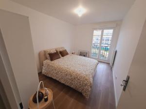 a white bedroom with a bed and a window at Cosy & Modern Flat Near Paris ! in Le Blanc-Mesnil