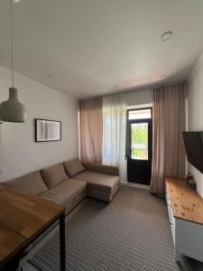 a living room with a couch and a window at Raduga Alfa in Chon-Sary-Oy