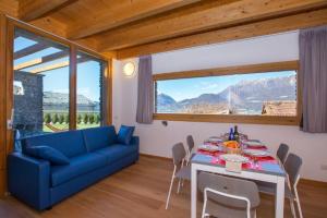 a living room with a table and a blue couch at paradiso del lago t4 in Bellano