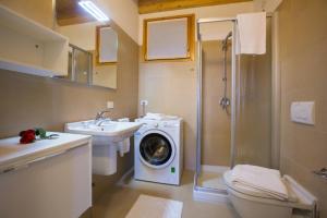 y baño con lavadora junto a un lavabo. en paradiso del lago t4, en Bellano
