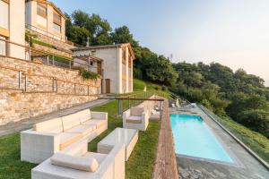 Una villa con piscina y un edificio. en paradiso del lago t4, en Bellano