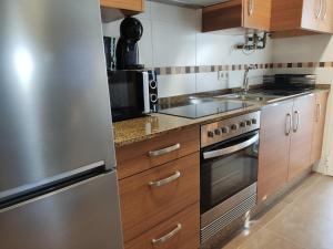 a kitchen with wooden cabinets and stainless steel appliances at Melide Suites By OL in Melide