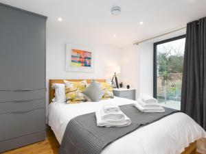 een slaapkamer met een groot bed met handdoeken erop bij Avon Cottage in St Ives