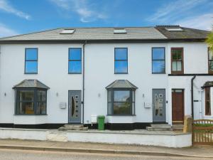 een wit huis met ramen en deuren aan een straat bij Avon Cottage in St Ives