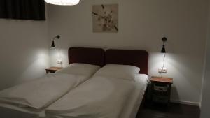 a bed in a bedroom with two lamps on two tables at APARTHOTEL am Südkanal in Hamburg