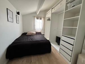 a small bedroom with a bed and a closet at La maison du bonheur in Mèze