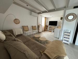 a living room with a couch and a tv at La maison du bonheur in Mèze
