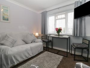 a living room with a couch and a table with flowers at Flat 4, Big Tree Holiday Flats in Paignton