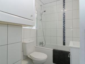 a white bathroom with a toilet and a shower at Flat 4, Big Tree Holiday Flats in Paignton +16 photos